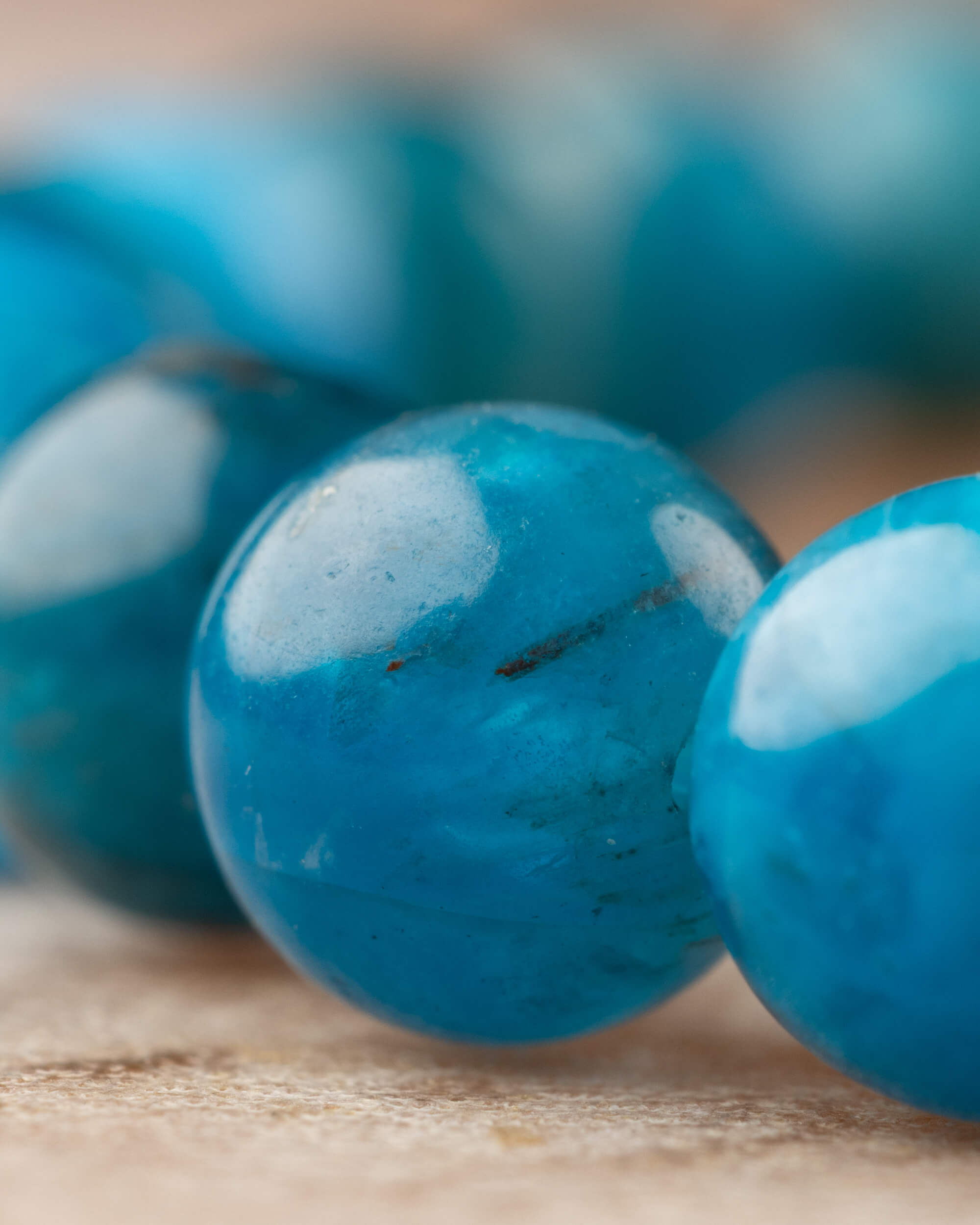 Detalle macro de cuentas de Apatita Azul con vetas internas