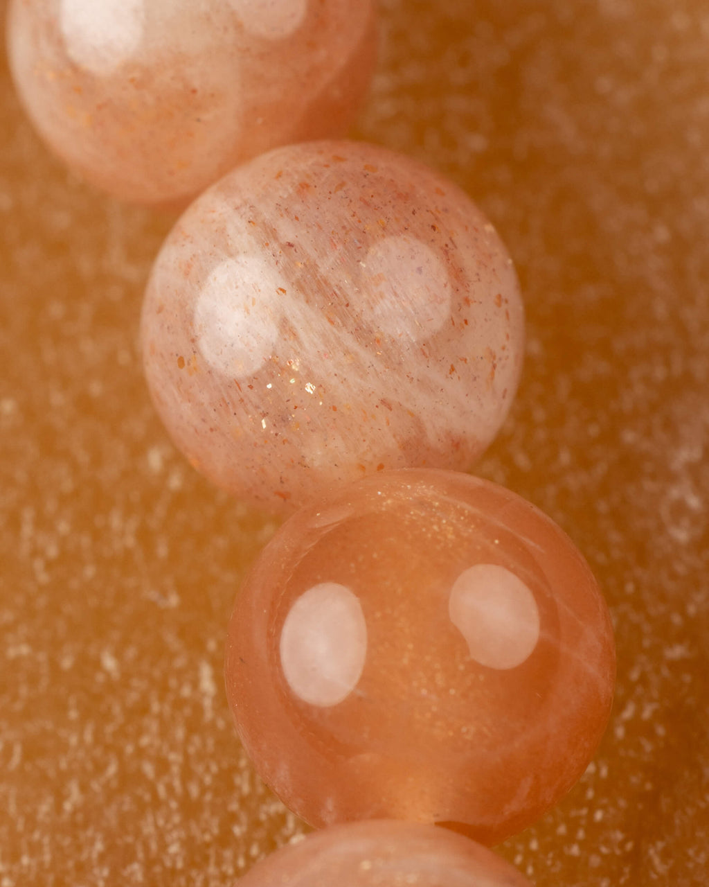 Detalle macro de las cuentas de Piedra Sol Naranja con brillos internos