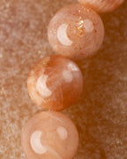 Detalle macro de las cuentas de Piedra Sol Naranja con reflejos dorados