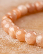 Pulsera de Piedra Sol Naranja en curva, enfoque en las cuentas del frente