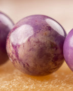 Detalle macro de una cuenta de Fosfosiderita con textura moteada morada y beige