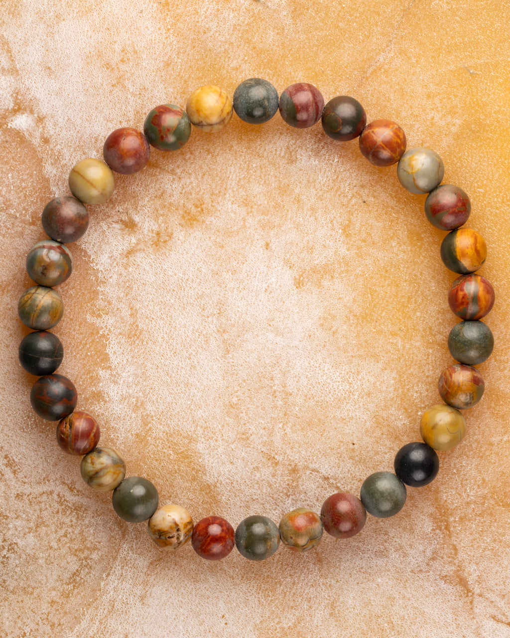Pulsera de Jaspe Picasso de 6 mm redonda, pieza completa sobre superficie de mármol