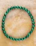 Pulsera de Malaquita de 6 mm, pieza completa sobre superficie ámbar clara