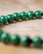 Pulsera de Malaquita con doble hilera de cuentas verdes sobre superficie clara