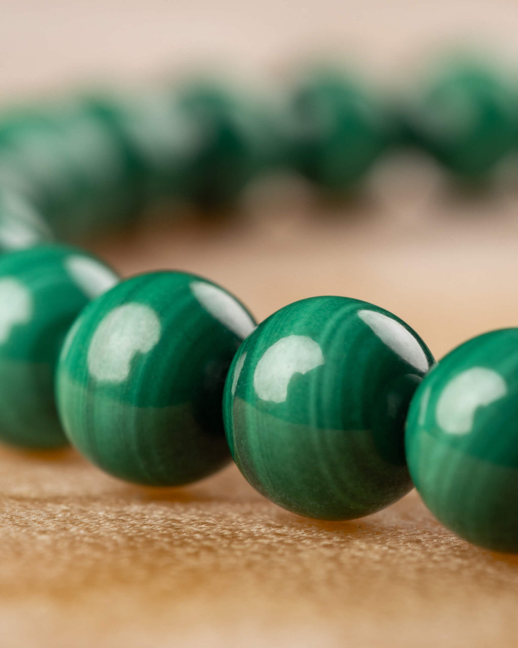 Pulsera de Malaquita con cuentas verdes en primer plano, hilera trasera difuminada