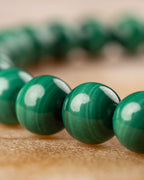 Pulsera de Malaquita con cuentas verdes en primer plano, hilera trasera difuminada