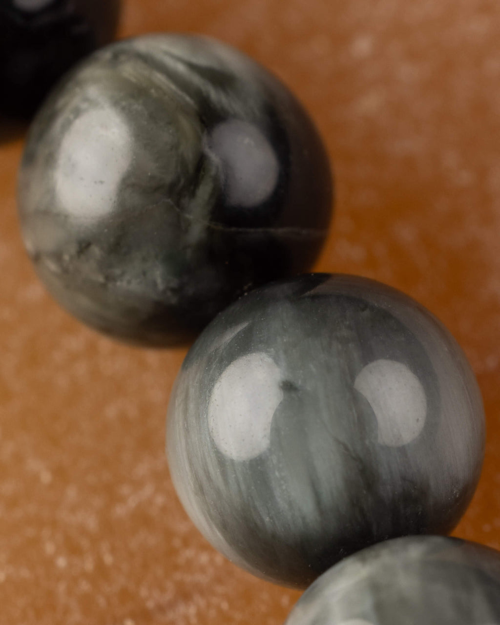 Detalle macro de una cuenta de Ojo de Halcon con vetas grises