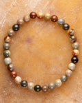Pulsera de Madera Petrificada de 6 mm, pieza completa sobre superficie ocre