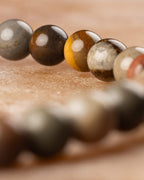 Detalle macro de las cuentas grises, cafés y amarillas de Madera Petrificada