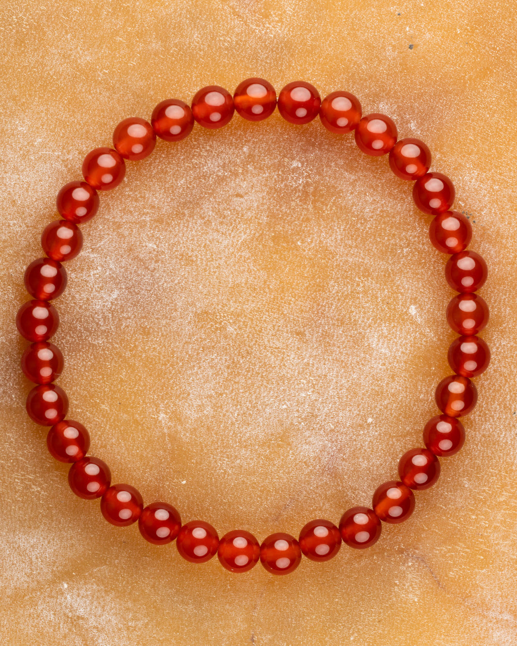 Pulsera de Cornalina de 6 mm, pieza completa en círculo sobre superficie clara