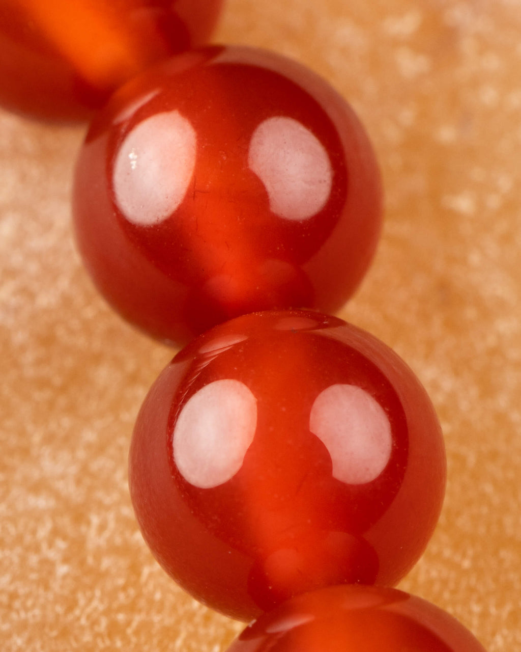 Detalle macro de las cuentas rojas de Cornalina en fila vertical