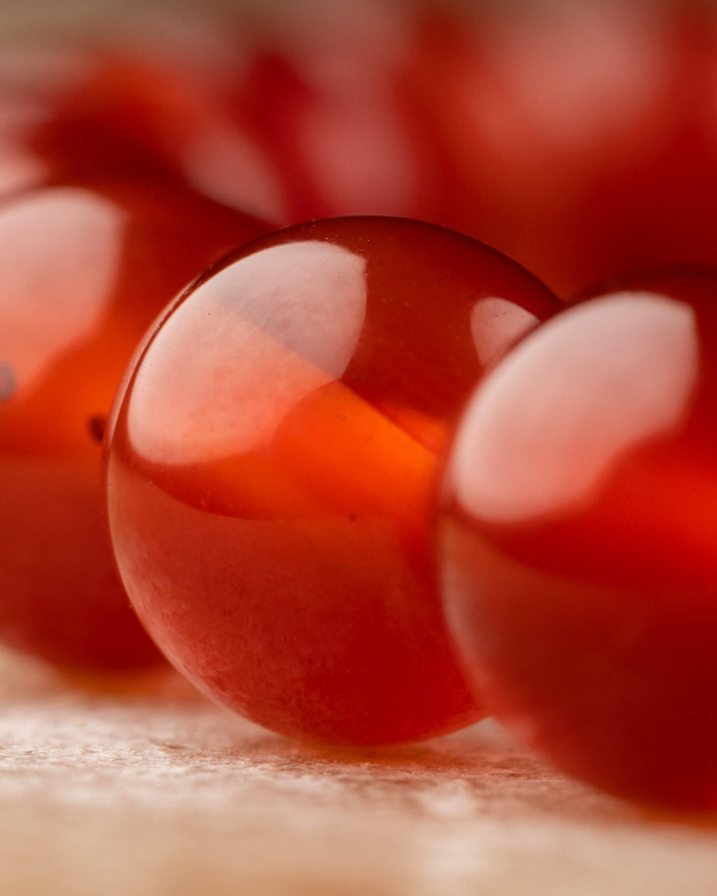 Detalle macro de una cuenta traslúcida de Cornalina con brillo
