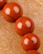 Cuentas de Jaspe Rojo en primer plano con una veta natural visible