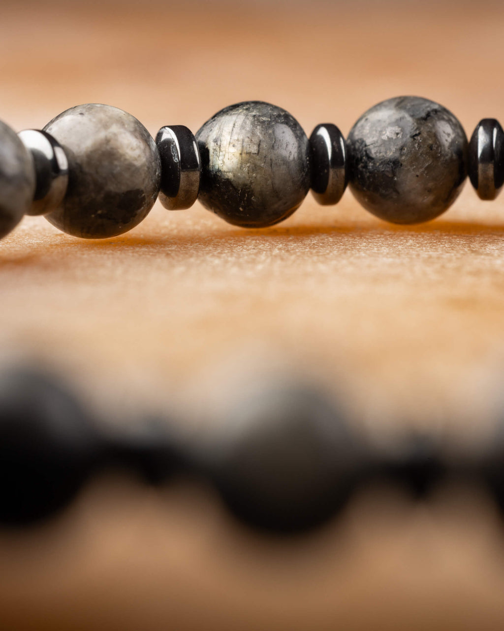 Pulsera de Larvikita y Hematita vista de cerca con la fila completa detrás
