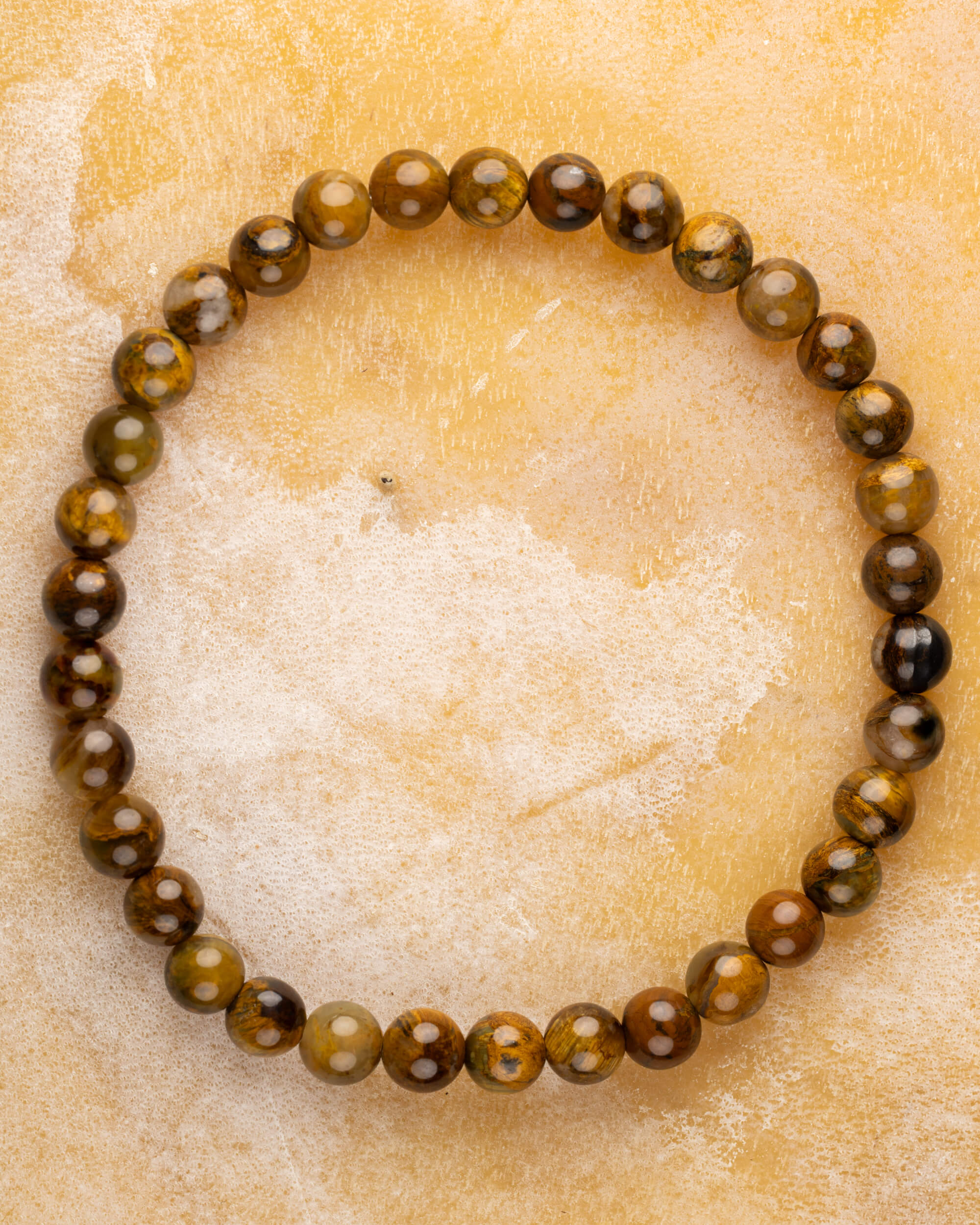 Pulsera de Pietersita amarilla de 6 mm, pieza completa en círculo sobre superficie clara