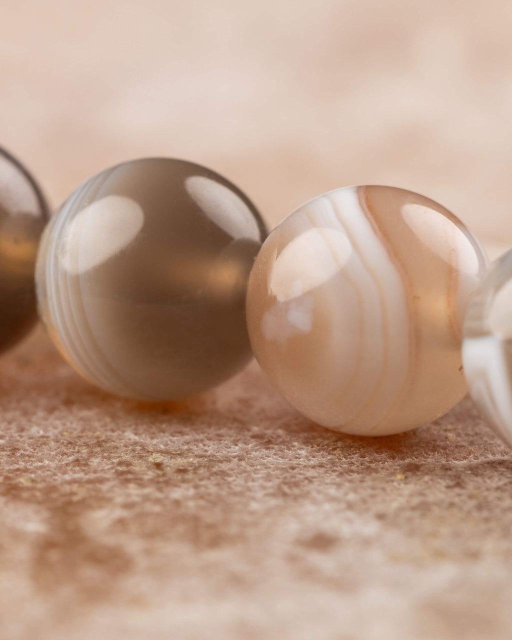 Detalle macro de cuentas de Ágata Botsuana gris y beige con bandas suaves