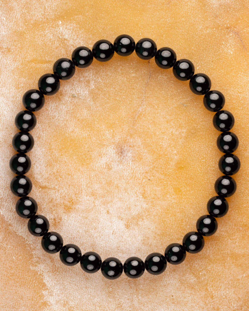 Pulsera de Turmalina Negra de 6 mm, pieza completa en círculo sobre superficie clara