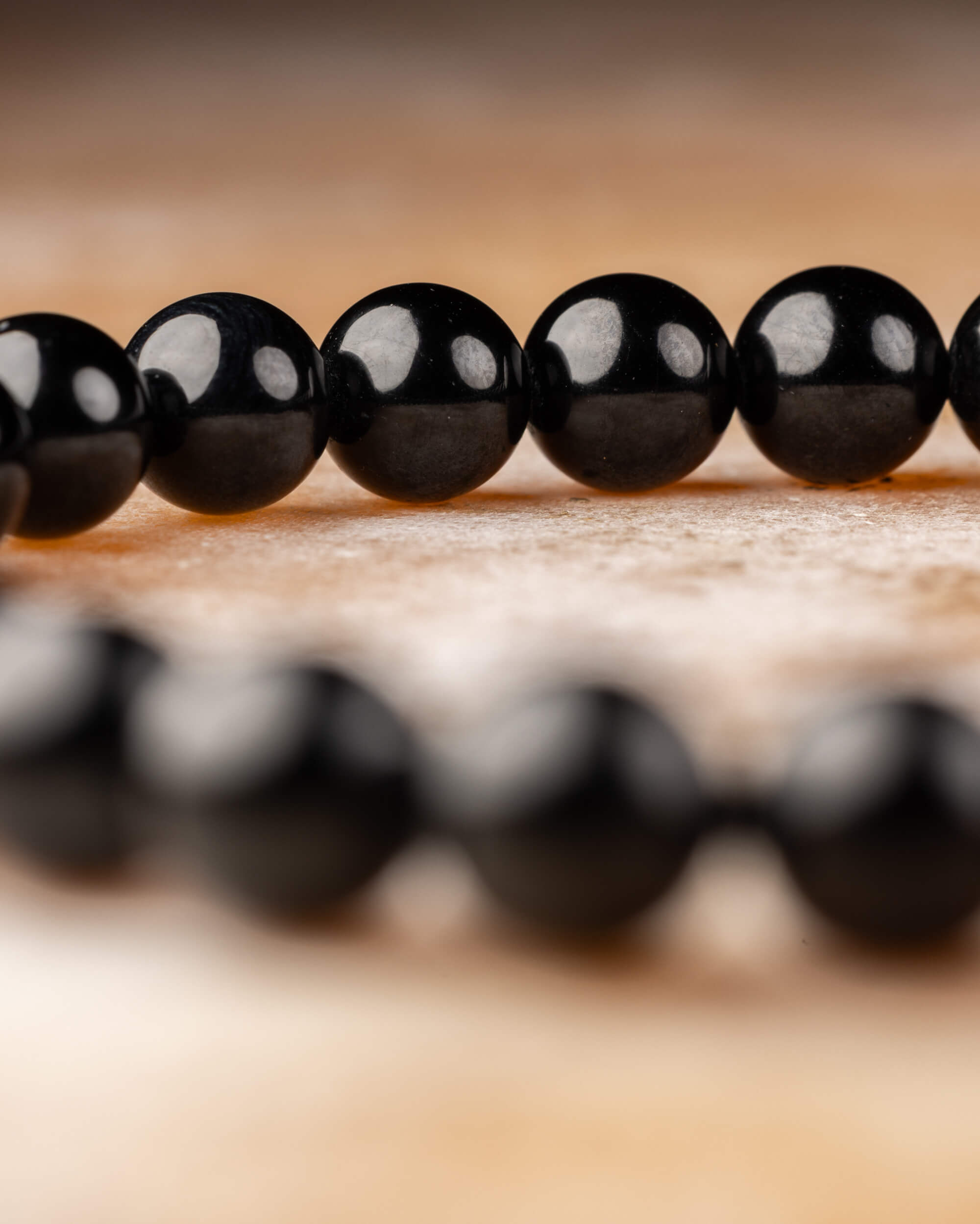 Pulsera de Turmalina Negra en curva, cuentas nítidas al frente y difuminadas atrás