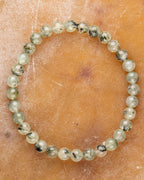 Pulsera de Prehnita de 6 mm, pieza completa en círculo sobre superficie color miel