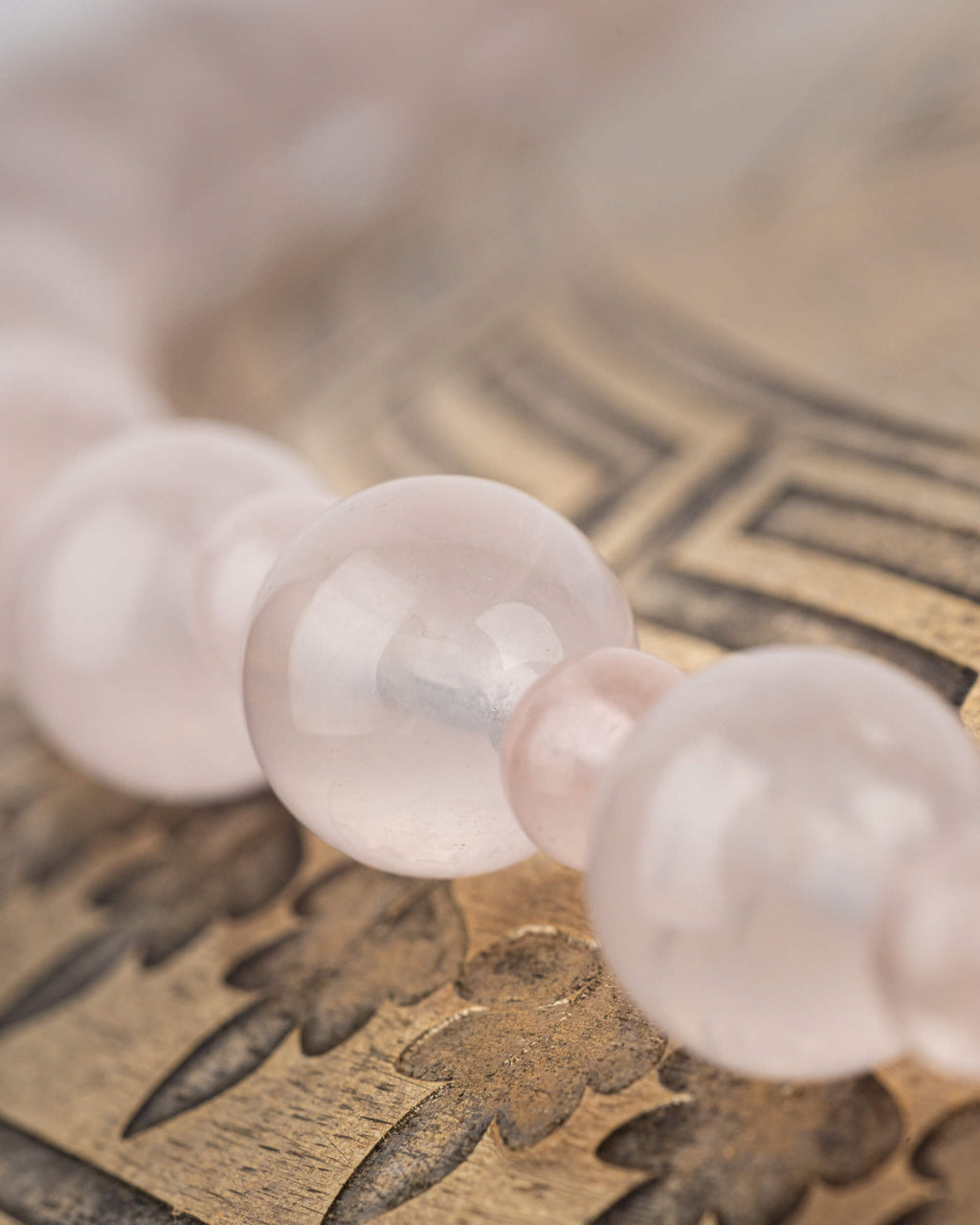 Detalle macro de las cuentas de Cuarzo Rosa con transparencia y brillo suave