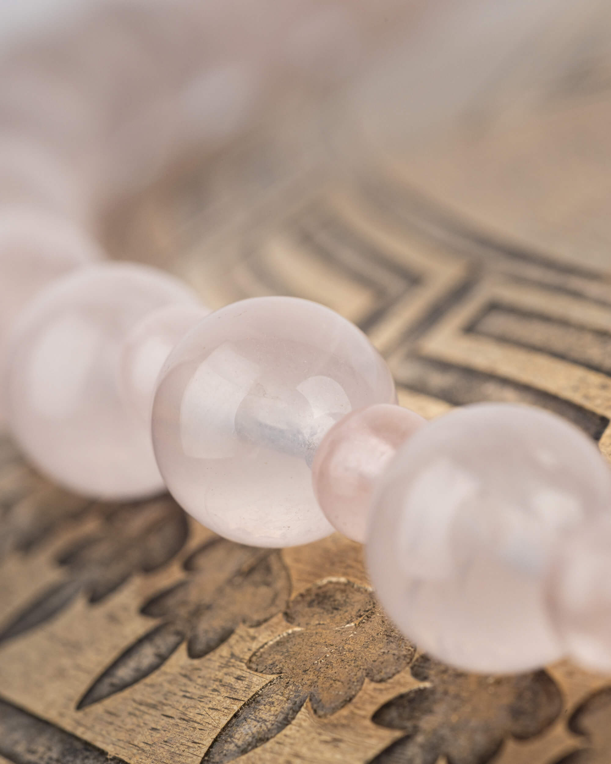 Detalle macro de las cuentas de Cuarzo Rosa con transparencia y brillo suave