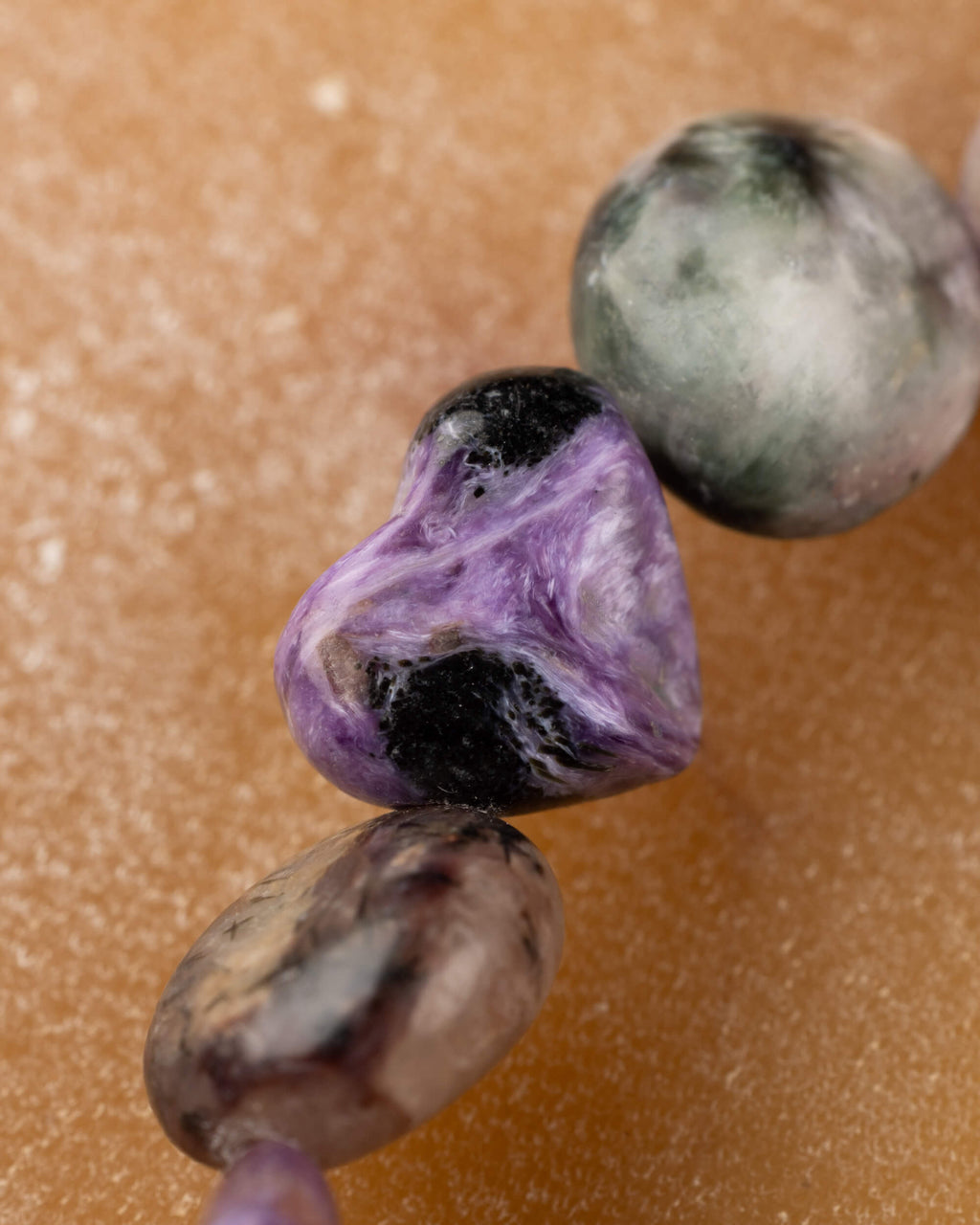 Detalle macro de piedra de Charoita en forma de corazón con veta negra