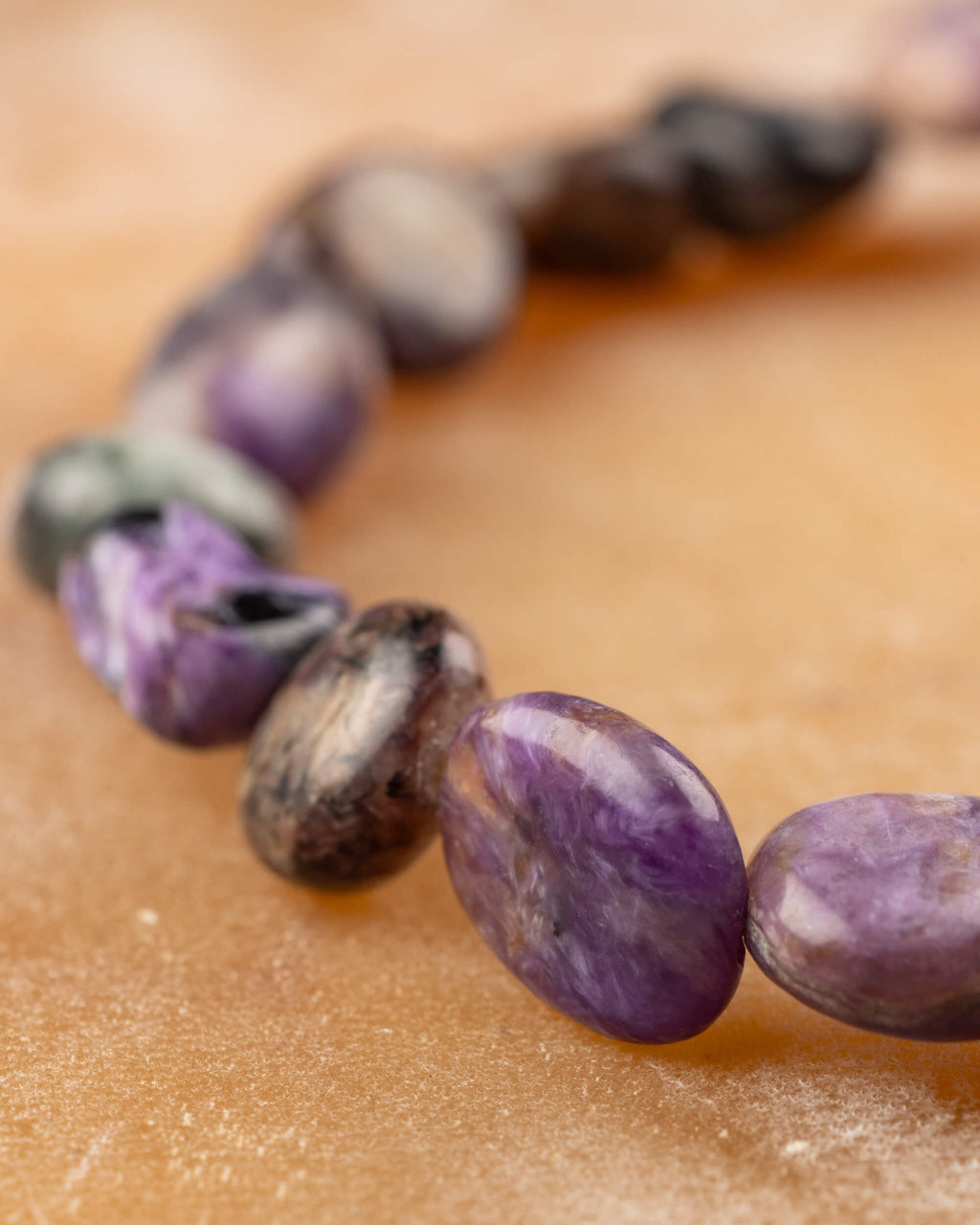 Detalle macro de piedras de Charoita irregulares con vetas y superficies pulidas