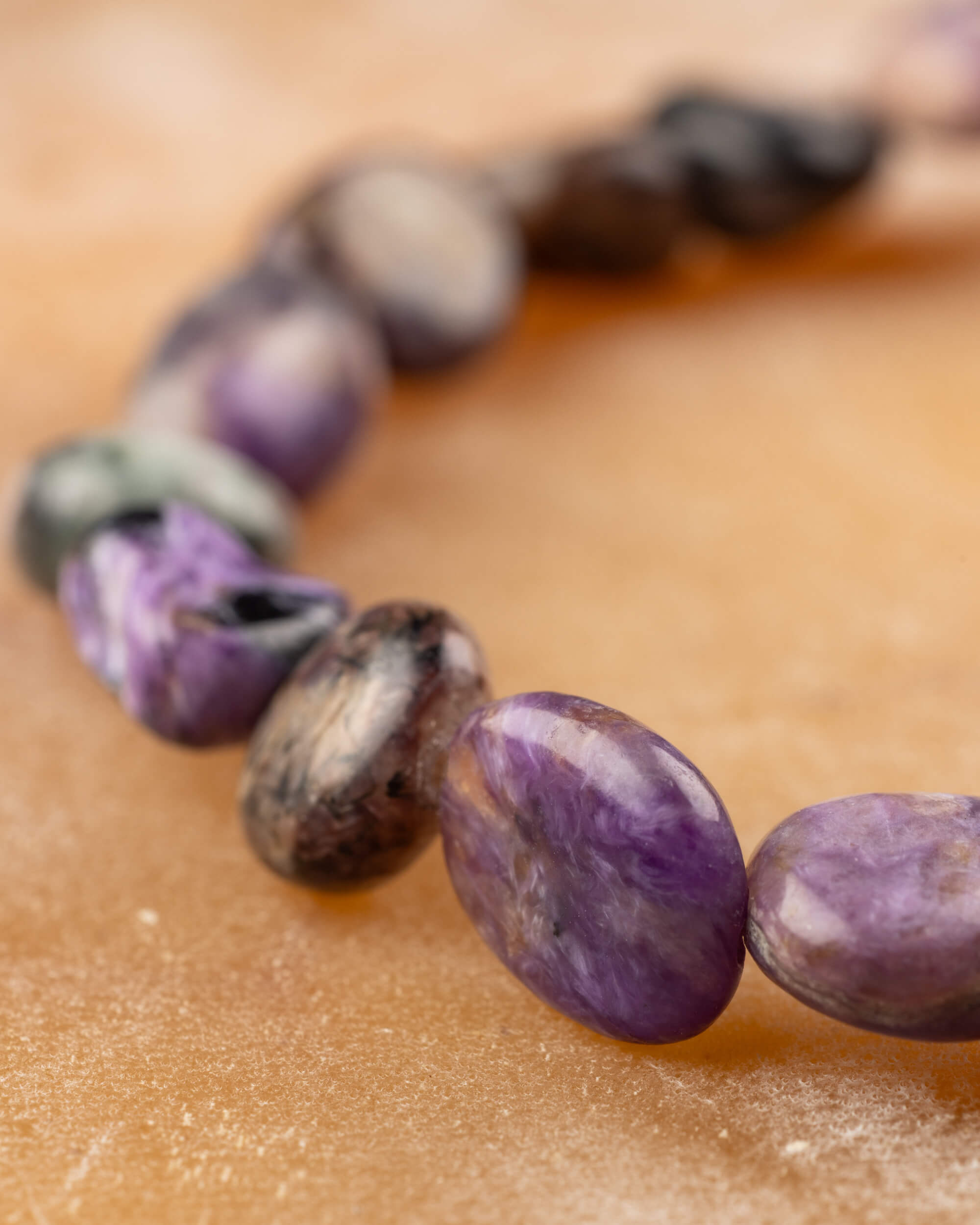 Detalle macro de piedras de Charoita irregulares con vetas y superficies pulidas