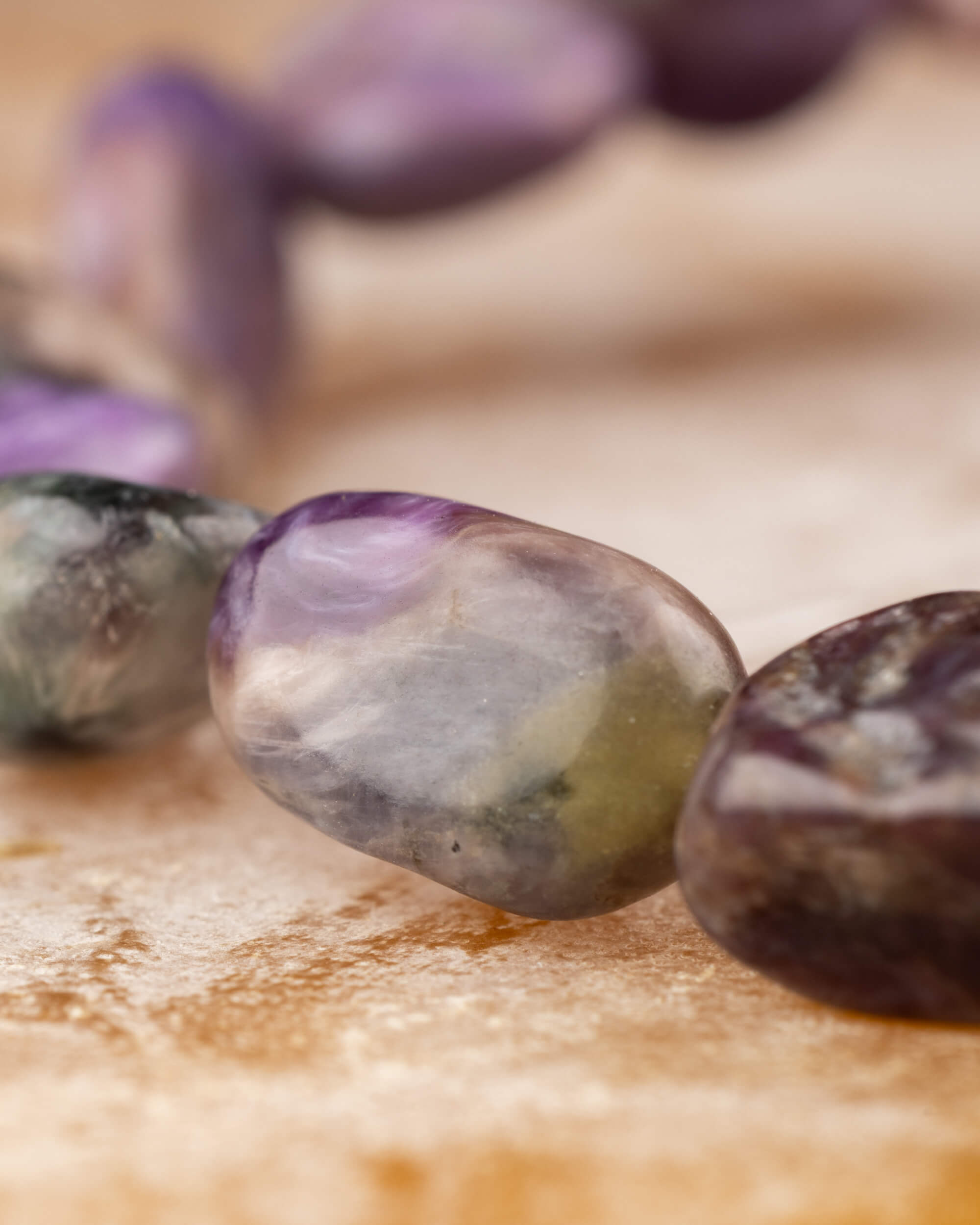 Detalle macro de piedra irregular de Charoita con veta morada y gris
