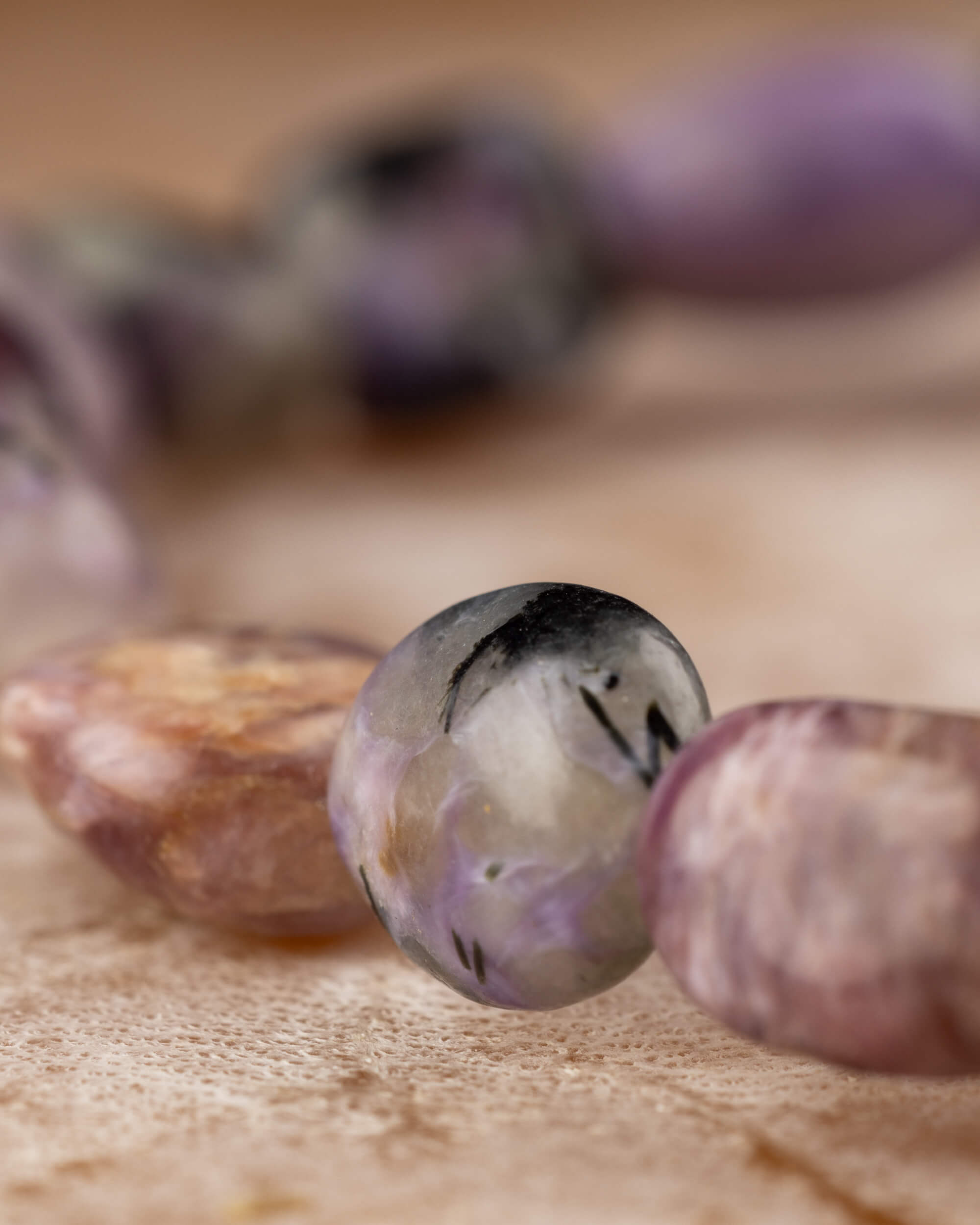 Detalle macro de las piedras irregulares de Charoita con vetas moradas y negras