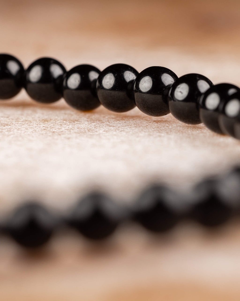 Pulsera de Turmalina Negra en perspectiva baja, cuentas alineadas en fila