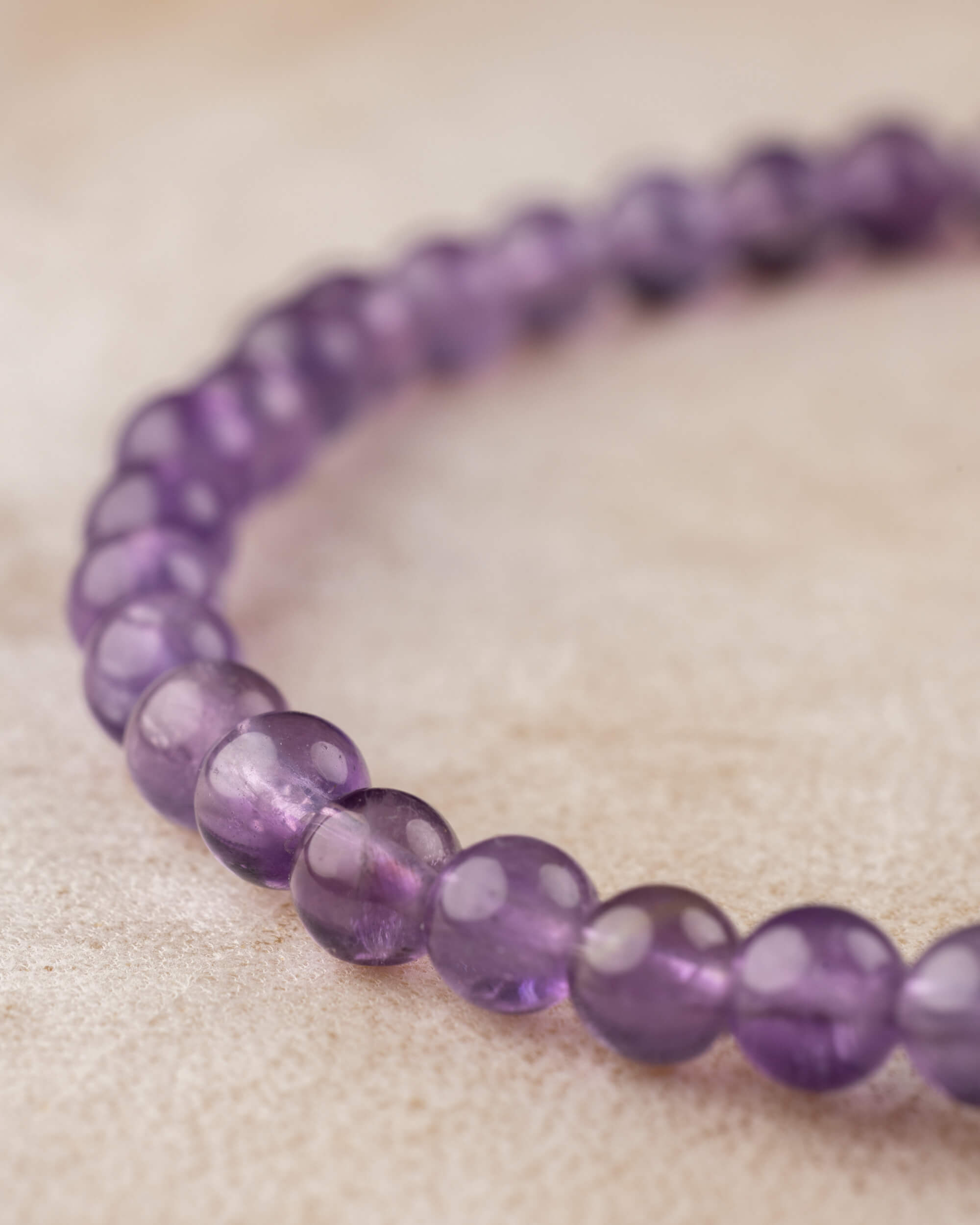 Pulsera de Amatista de 4 mm en curva, cuentas alineadas sobre superficie clara