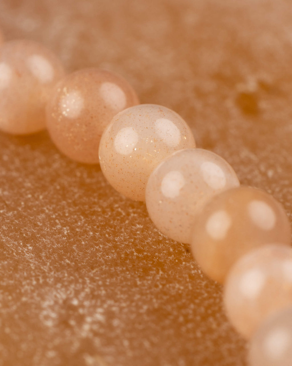 Detalle macro de las cuentas pequeñas de Piedra Sol Naranja de 4 mm