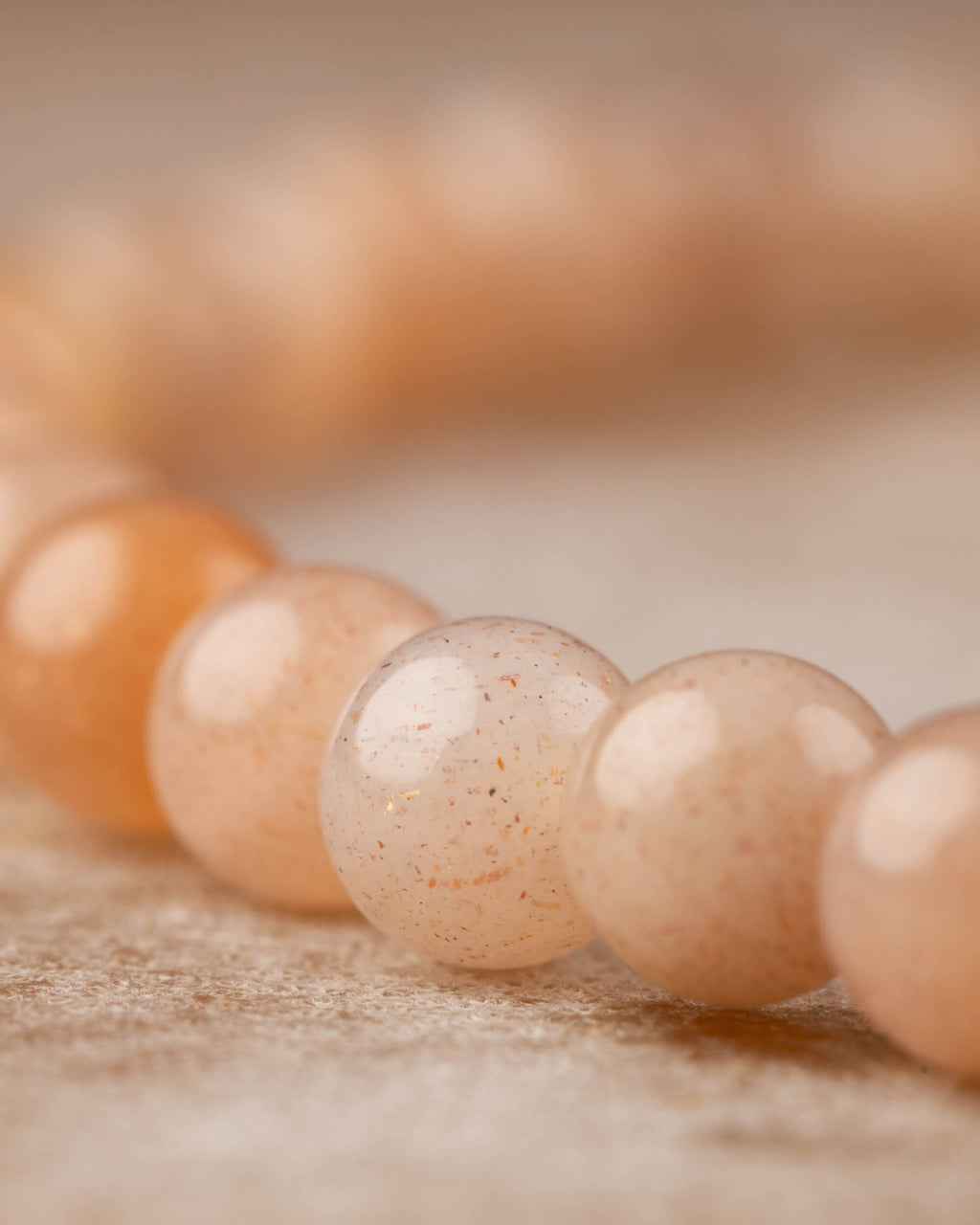 Detalle macro de las cuentas de Piedra Sol Naranja en tonos cálidos y suaves