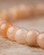 Detalle macro de las cuentas de Piedra Sol Naranja en tonos cálidos y suaves