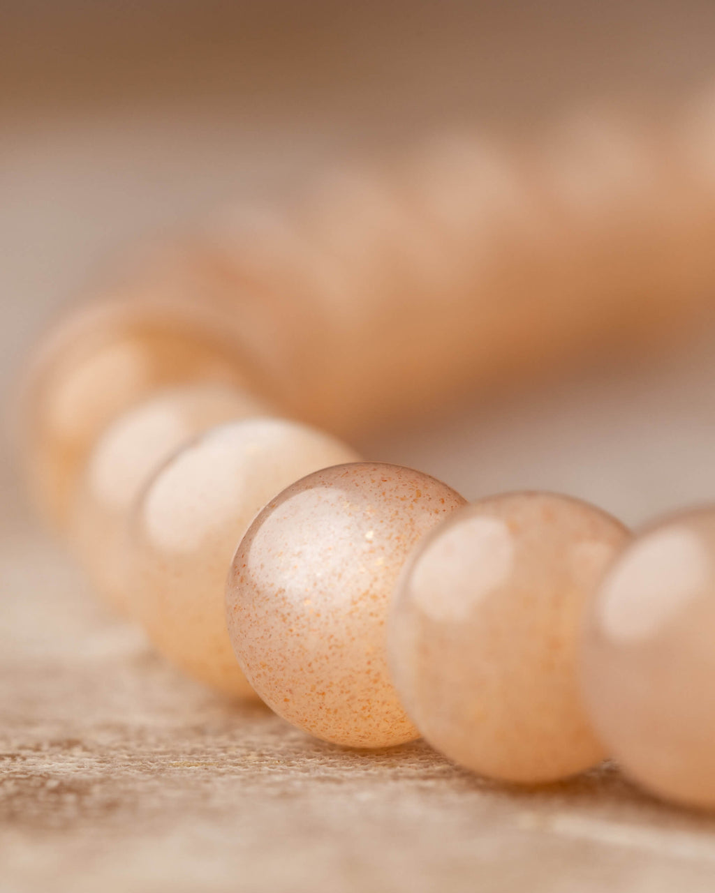Detalle macro de las cuentas pequeñas de Piedra Sol Naranja con brillo suave