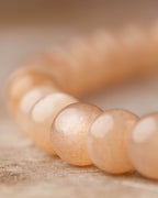 Detalle macro de las cuentas pequeñas de Piedra Sol Naranja con brillo suave
