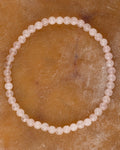 Pulsera de Cuarzo Rosa de 4 mm, pieza completa en círculo sobre superficie marmoleada