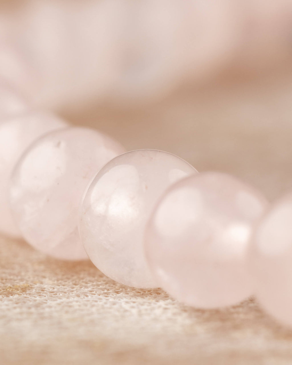 Detalle macro de las cuentas de Cuarzo Rosa, textura translucida en primer plano