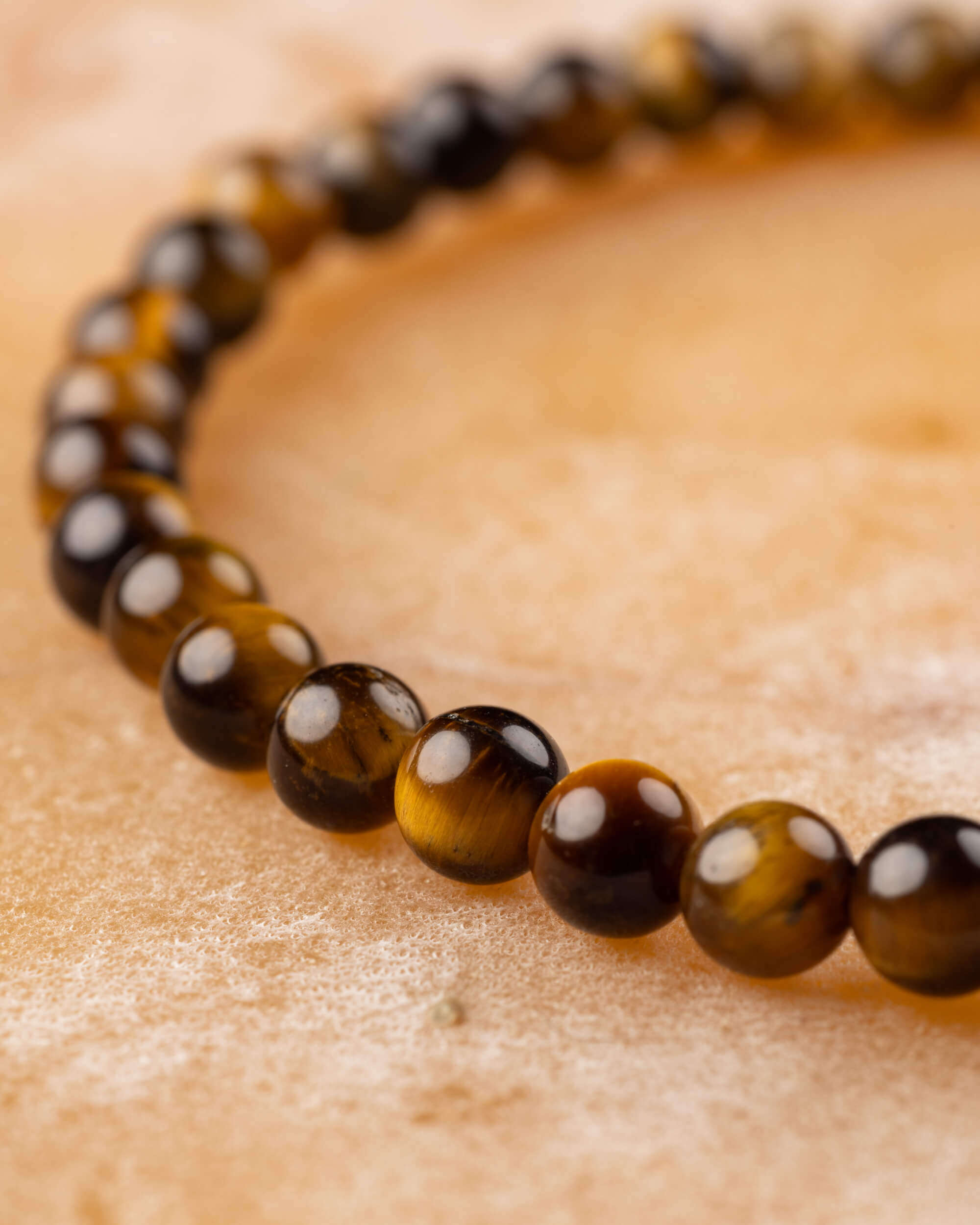 Pulsera de Ojo de Tigre curvada en primer plano sobre superficie clara