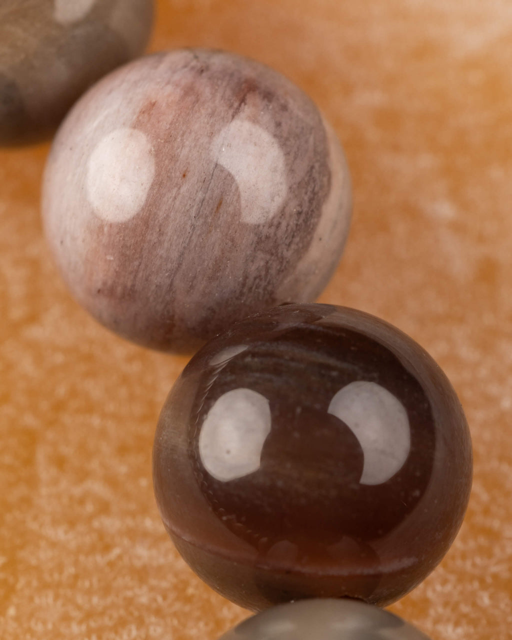 Detalle macro de una cuenta clara con manchas cafés de Madera Petrificada