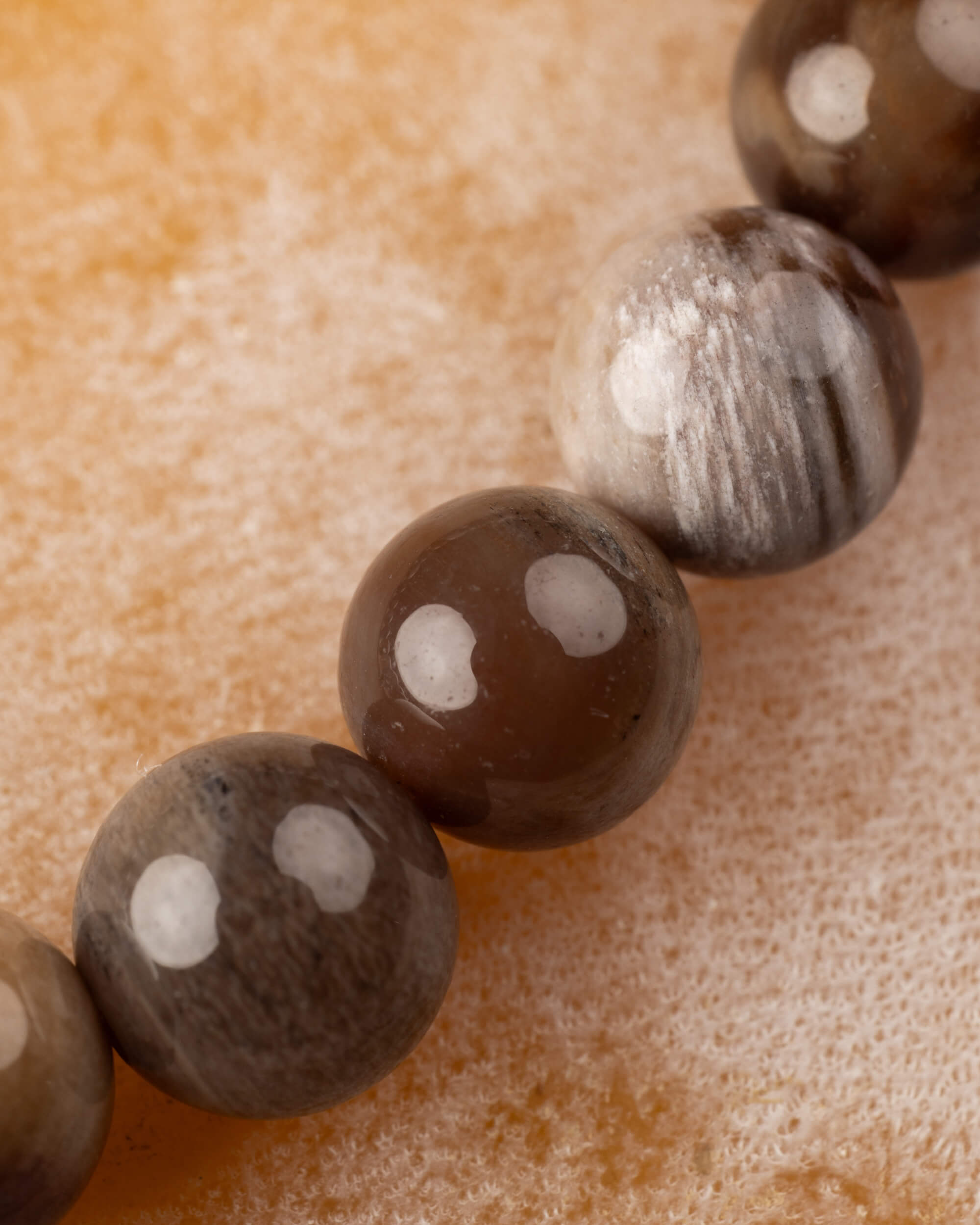 Detalle macro de las cuentas de Madera Petrificada en tonos grises y café