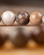 Detalle macro de una cuenta oscura de Madera Petrificada al frente de la fila