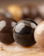 Detalle macro de las cuentas claras y oscuras de Madera Petrificada en fila