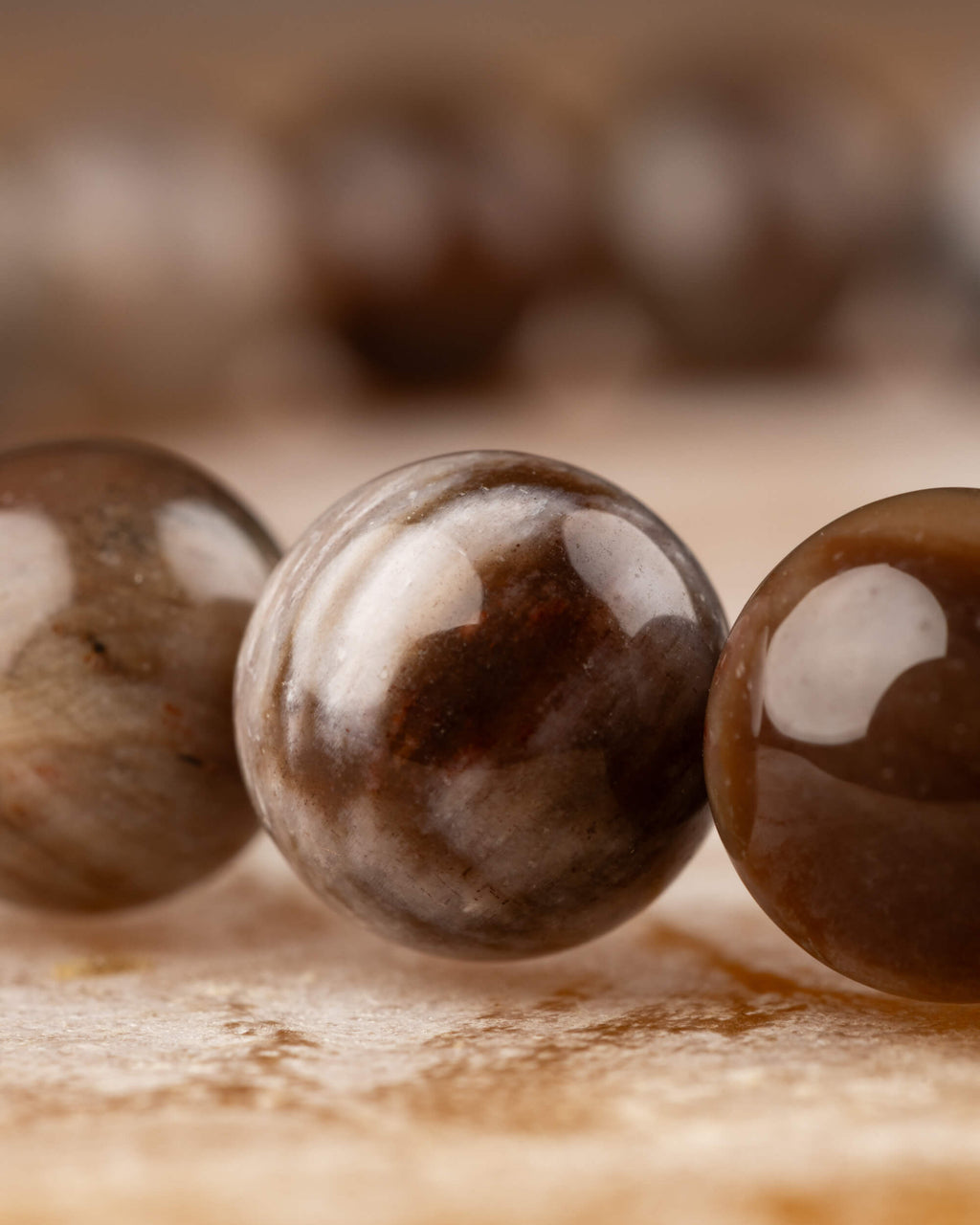 Detalle macro de las cuentas grises y cafés brillantes de Madera Petrificada