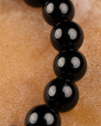 Detalle macro de las cuentas de Turmalina Negra siguiendo la curva de la pulsera