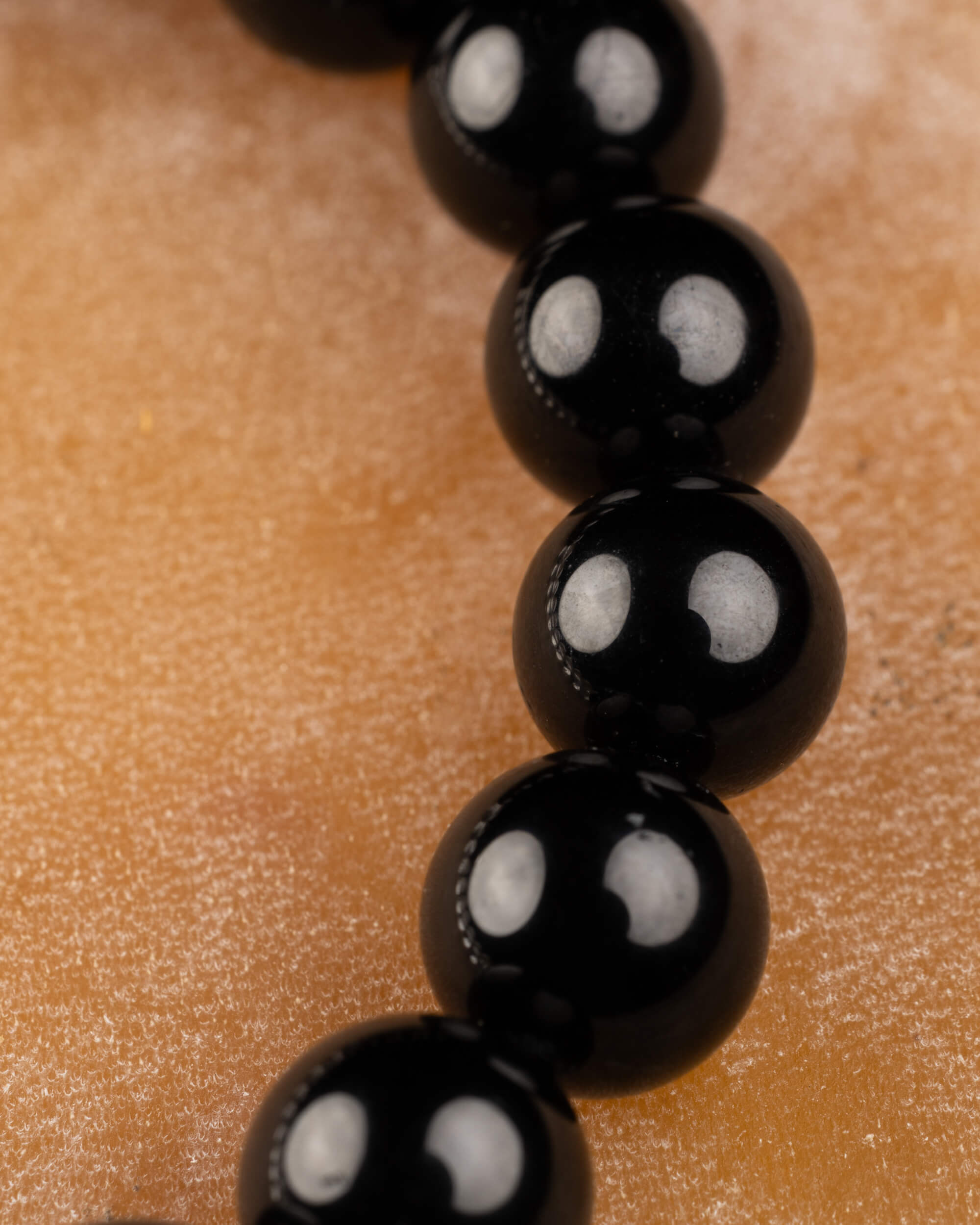 Detalle macro de las cuentas de Turmalina Negra siguiendo la curva de la pulsera