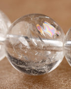 Detalle macro de una cuenta de Cuarzo Transparente con reflejos de luz e inclusiones internas