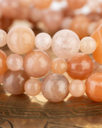 Detalle macro de varias hebras de cuentas de Piedra Sol Naranja entrelazadas