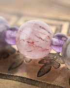 Detalle macro de una cuenta de Turmalina Rosa entre Amatista en el codificador